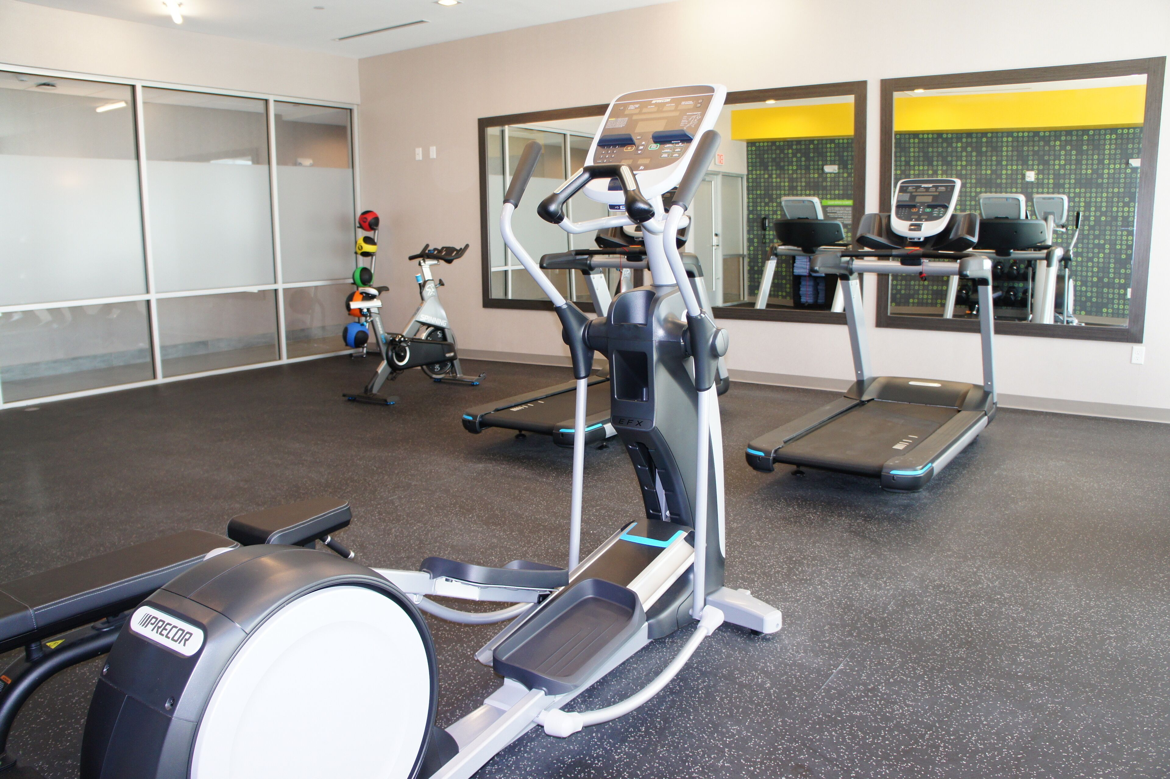 Ett gym med konditionsutrustning, inklusive löpband och en crosstrainer.