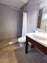 Une salle de bain moderne équipée d’une douche, de toilettes et d’un lavabo.