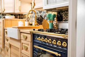 Une cuisine avec des meubles de rangement en bois, une cuisinière et un four à micro-ondes.