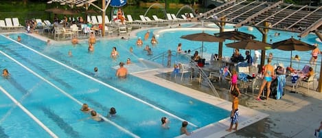 A swimming pool with multiple lanes, sun loungers, and umbrellas.