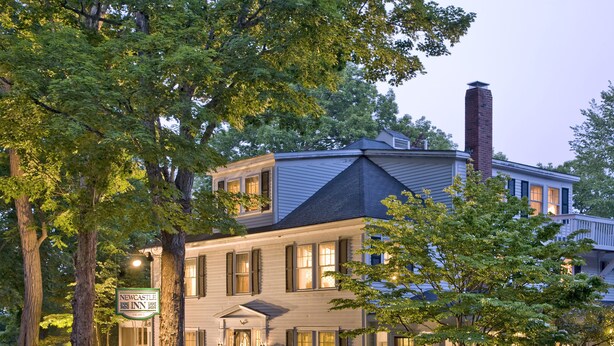 A two-story inn with a stone facade, a chimney, and a sign indicating it is a New Castle Inn. - Newcastle Inn (Newcastle)