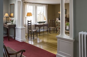 Classic design room with a dining table, chairs, and a window with white curtains.