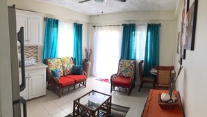 Una sala de estar con dos sofás, una mesa de centro y una mesa de comedor con adornos.