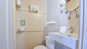 A small, clean bathroom with a toilet, sink, and towel rack. - Kokopelli Lodge (Moab)
