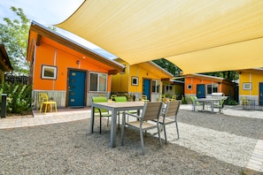 Área de pátio com mobiliário de exterior, mesa e churrasqueira.