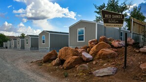A row of mobile homes with a sign indicating 'Red Sands' and 'Nightly Rentals'. - Red Sands Habitation (Moab)