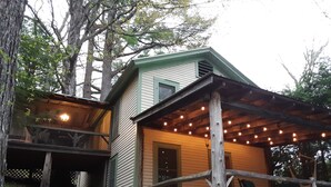 Eine Hütte mit überdachter Veranda und Lichterkette.