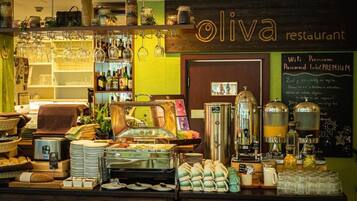 A restaurant counter with a coffee machine, glassware, and various food items.