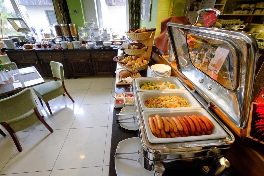 A buffet setup with various food items, including hot dogs and a salad bar.