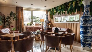 Un espace de détente moderne avec des canapés en cuir, des tables en bois et un grand vase décoratif.