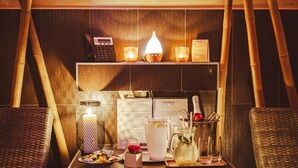 Un espace bar avec un comptoir en bois, une caisse enregistreuse, un tableau affichant le menu et une bouteille de champagne.