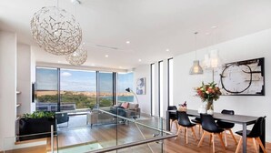 Un interior moderno con zona de comedor, ventanas amplias y vistas al exterior.