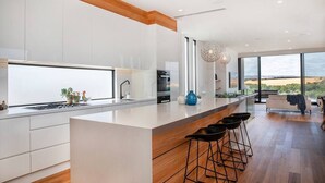 Una cocina moderna con una isla grande, taburetes de bar y vistas al paisaje desértico.