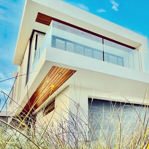 A modern two-story building with large windows and a flat roof.