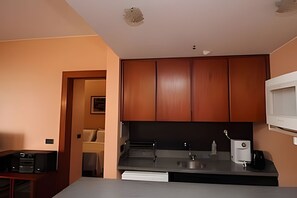 A kitchen with wooden cabinets, a microwave, a sink, and a countertop. - OZPED Flats Particulares Bonaparte (Brasília)