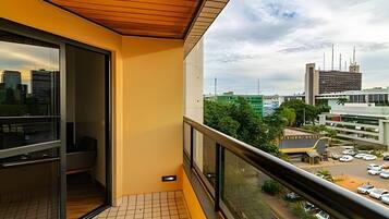 A balcony with a tiled floor, a wooden ceiling, and a city view.