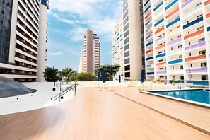 A modern hotel with a pool, multiple floors, and a central staircase. - OZPED Flats Particulares Bonaparte (Brasília)