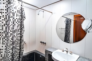 Ein Badezimmer mit Dusche, Waschbecken, Spiegel und einer waschbär-gemusterten Duschvorhang.