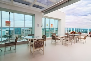 A modern office space with large windows, glass tables, and chairs. - OZPED Flats Particulares Saint Moritz (Brasília)