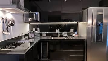 A modern kitchen with stainless steel appliances, a built-in oven, and a refrigerator.