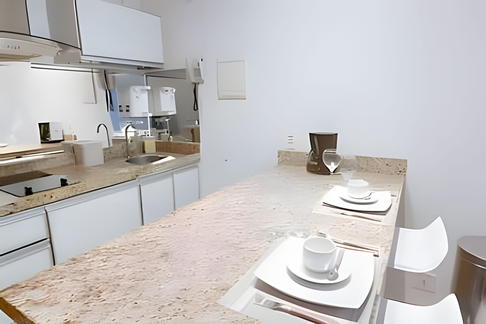 Een moderne keuken met een marmeren aanrecht, roestvrijstalen apparatuur en een minimalistisch ontwerp.
