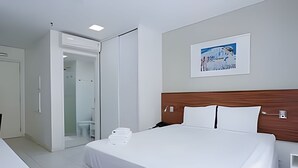 Une chambre d’hôtel avec un lit, une salle de bain et une douche.