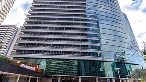 Un bâtiment moderne à plusieurs étages, doté de grandes fenêtres en verre réfléchissant, d’une façade incurvée et d’un toit plat.