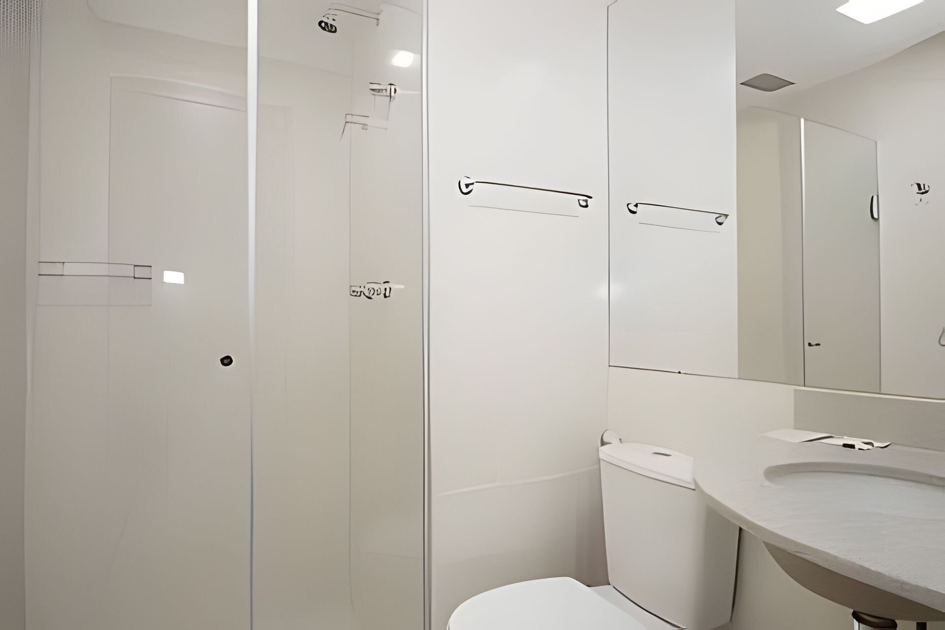 A modern bathroom with a toilet, shower, and sink.