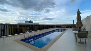 Une piscine sur le toit offrant une vue dégagée sur le ciel et les bâtiments environnants.