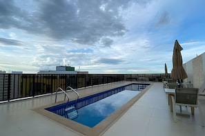 A rooftop swimming pool with a clear view of the sky and surrounding buildings. - OZPED Flats Particulares Nobile Suítes (Brasília)