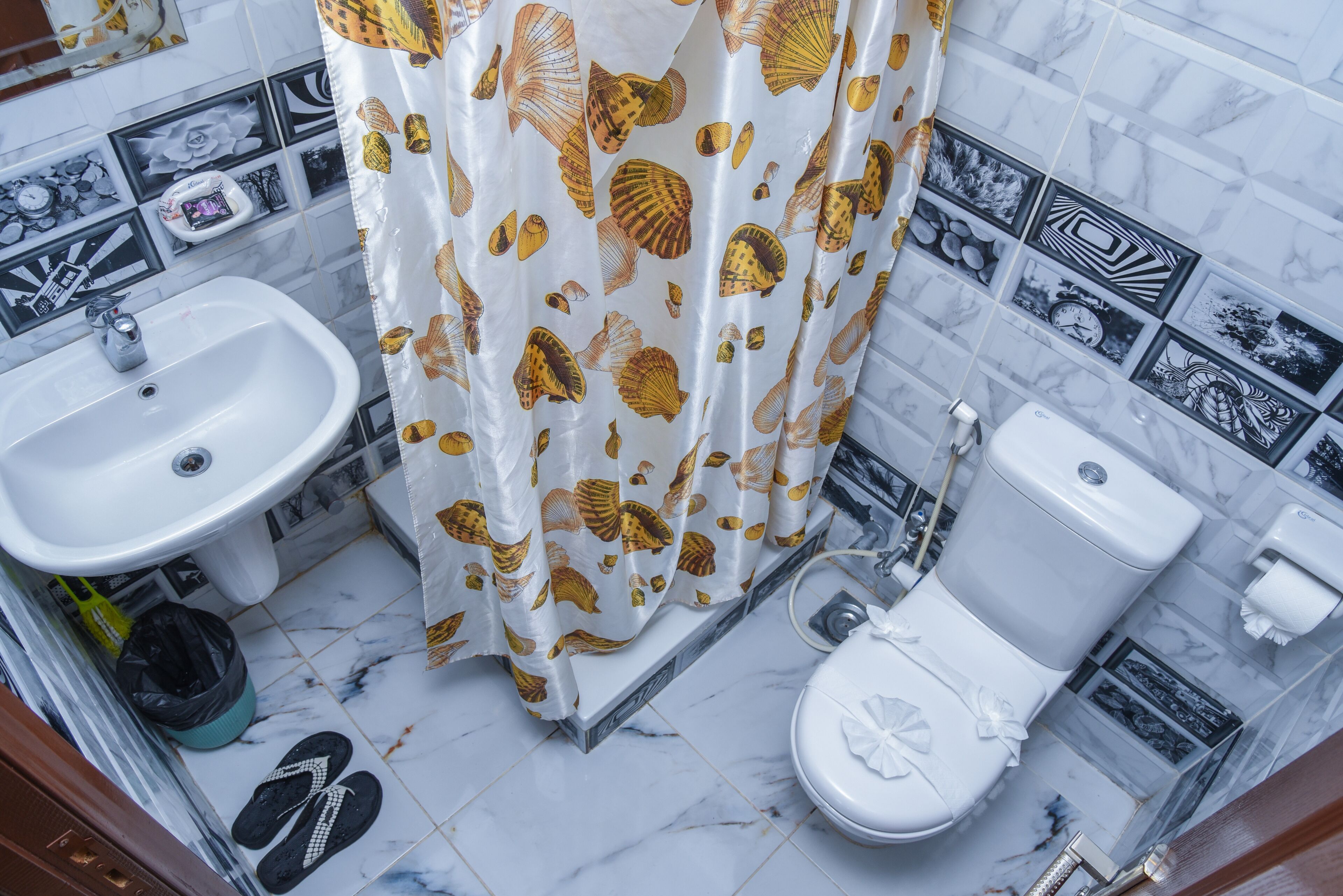 Ein Badezimmer mit Waschbecken, Toilette und Duschvorhang mit Muschelmuster.