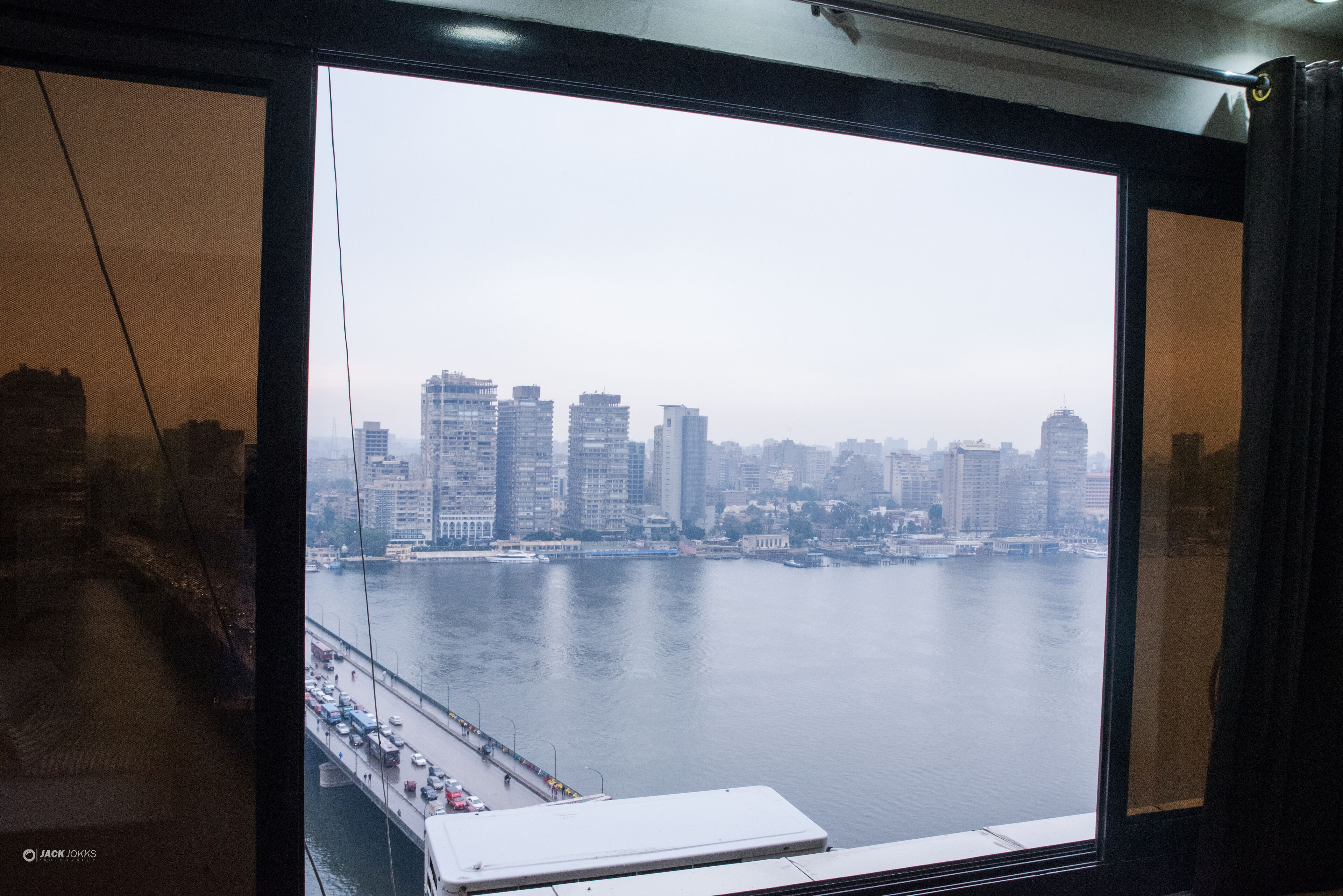 A view from a high-rise window overlooking a city skyline and a body of water.