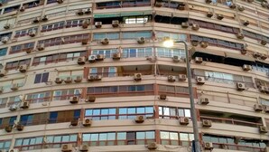 A multi-story building with numerous balconies, air conditioning units, and a visible storefront at the ground level. - Nile sky hotel and suites (Cairo)