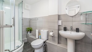 A modern bathroom with a glass shower enclosure, a toilet, a sink, and a mirror. - London Street, Andover, Hampshire, SP102NU, United Kingdom (Andover)