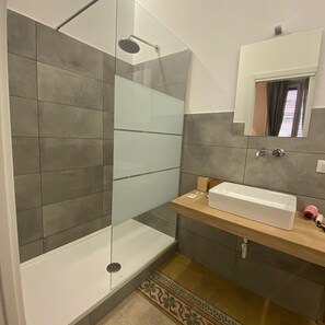 Habitació quàdruple Deluxe | Bany | Dutxa, capçal de dutxa tipus cascada i articles de tocador gratuïts 