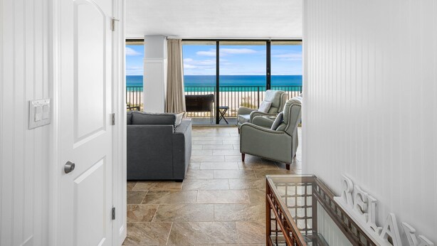 A room with a view of the ocean, a grey sofa, a beige armchair, and a small table. - 1st Floor ~ Pet Friendly ~ Fall Specials! Free Beach Chair Service! (Panama City Beach)