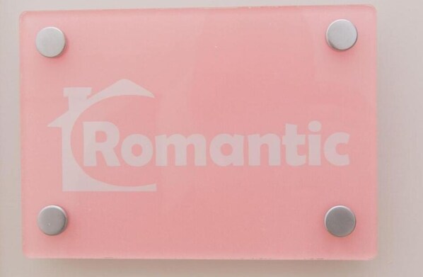 Ein pinkes Schild mit der Aufschrift 'Romantic' und einem Herzsymbol.