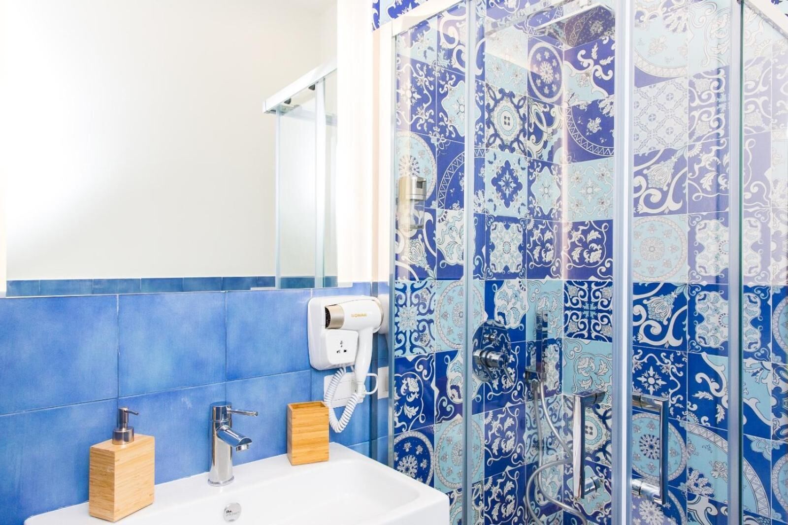 Une salle de bain équipée d’un lavabo, d’un sèche-mains et d’un miroir.