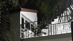 A two-story building with a balcony, a door, and a window. - un séjour inoubliable. Surpresseur, chauffe eau, Clim , piscine, plage … jardin. (Ngaparou)