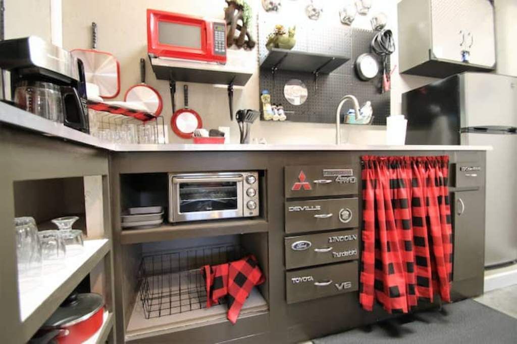 A kitchen with a built-in microwave, toaster, and storage drawers.
