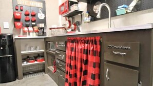 A kitchenette with a coffee station, a refrigerator, and a sink.