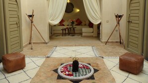 A cozy interior with a seating area, a decorative fountain, and a patterned floor. - RIAD ET SPA MISRIA LES OLIVIERS (Marrakech)
