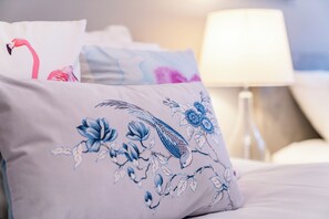 A bed with decorative pillows featuring floral and bird designs. - London Street, Andover, Hampshire, SP102NU, United Kingdom (Andover)