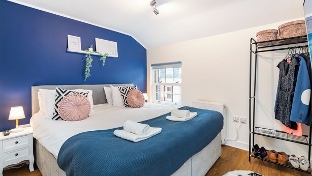 A bedroom with a bed, bedside tables, a clothing rack, and a window. - London Street, Andover, Hampshire, SP102NU, United Kingdom (Andover)