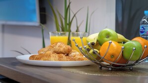 A breakfast setting with croissants, a fruit basket, and glasses of orange juice on a table. - London Street, Andover, Hampshire, SP102NU, United Kingdom (Andover)