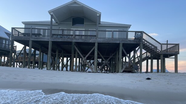 A wooden pier structure with a large building on stilts, a covered walkway, and a view of the beach. - BEACHES OPEN 5 Bedroom, 5 Bathroom Gulf Beach Front Home  (Dauphin Island)