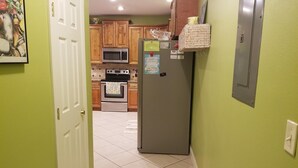 A kitchen with wooden cabinets, a stainless steel refrigerator, a microwave, and an oven. - BEACHES OPEN 5 Bedroom, 5 Bathroom Gulf Beach Front Home  (Dauphin Island)