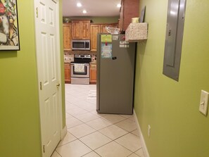 Una cocina con armarios de madera, un refrigerador de acero inoxidable, un microondas y un horno.