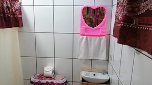 A bathroom with a toilet, sink, and a mirror with a heart-shaped frame. - Pensión y Cabinas Colibrí Monteverde B&B (Monteverde)