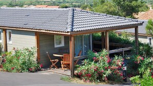 A small house with a tiled roof, a porch with wooden furniture, and a view of a rural landscape. - Beautiful apartment in villa for 6 people with WIFI, pool, A/C, terrace and pets allowed (Agde)